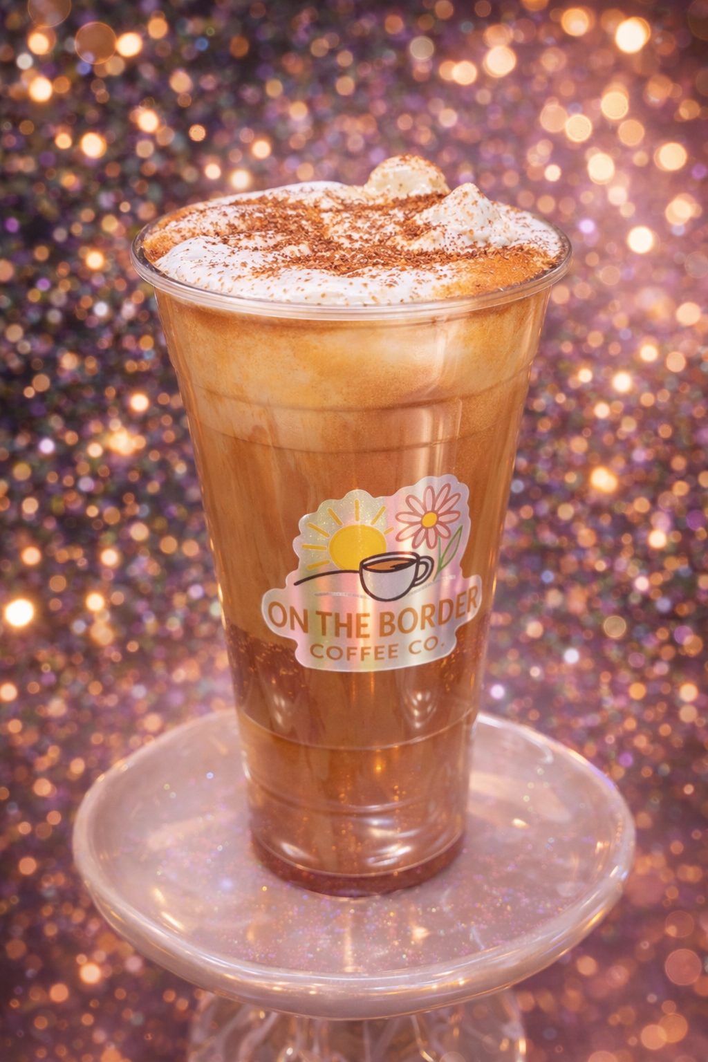 Iced coffee drink with whipped cream and cinnamon, on a stand, with a logo 