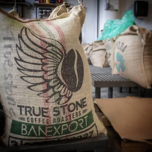 Burlap bag of coffee beans with winged coffee bean logo, 