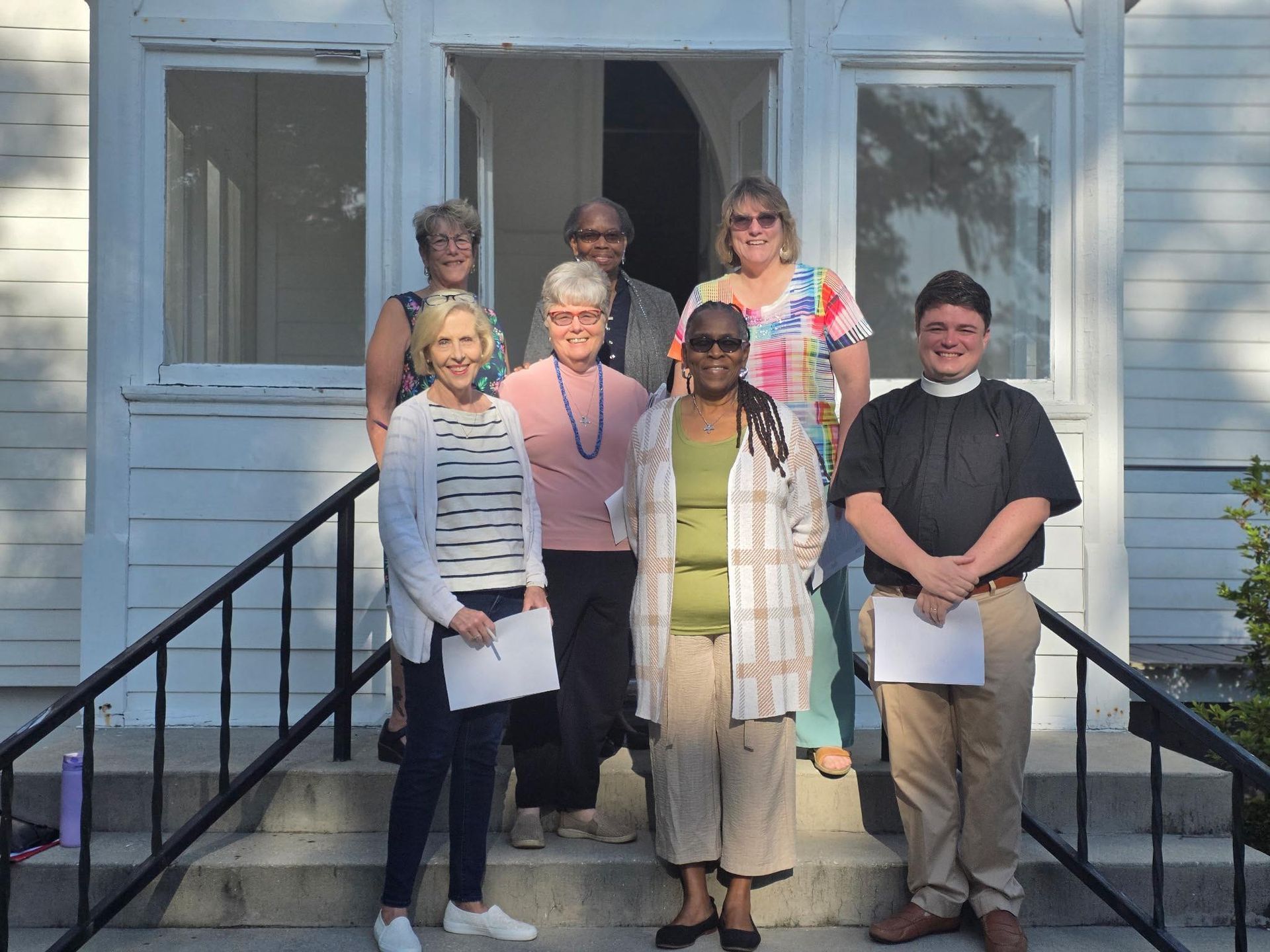 Fr. William with a group of ladies on the porch of the Historic Chapel of St. James