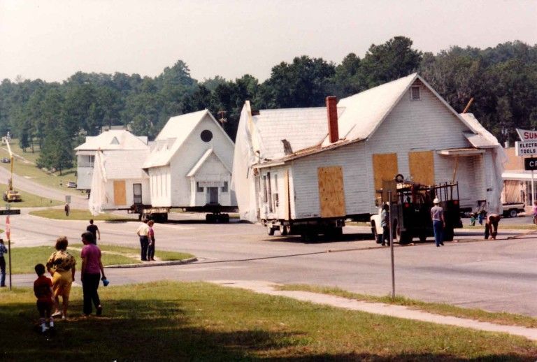 St. James buildings being moved down the street with onlookers standing by