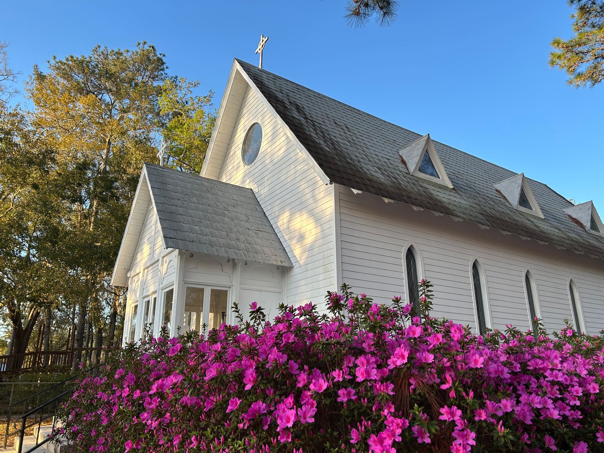 The exterior of St. James Episcopal Church Historic Chapel with blooming azaleas on the side
