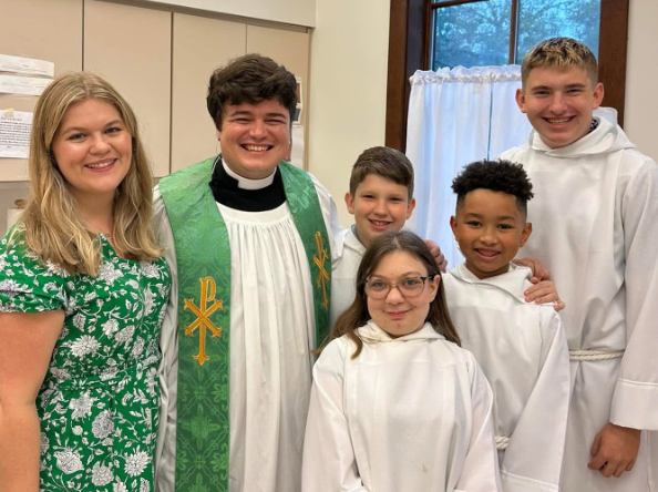 Fr. William and wife Alyson with a group of acolytes in their white vestments