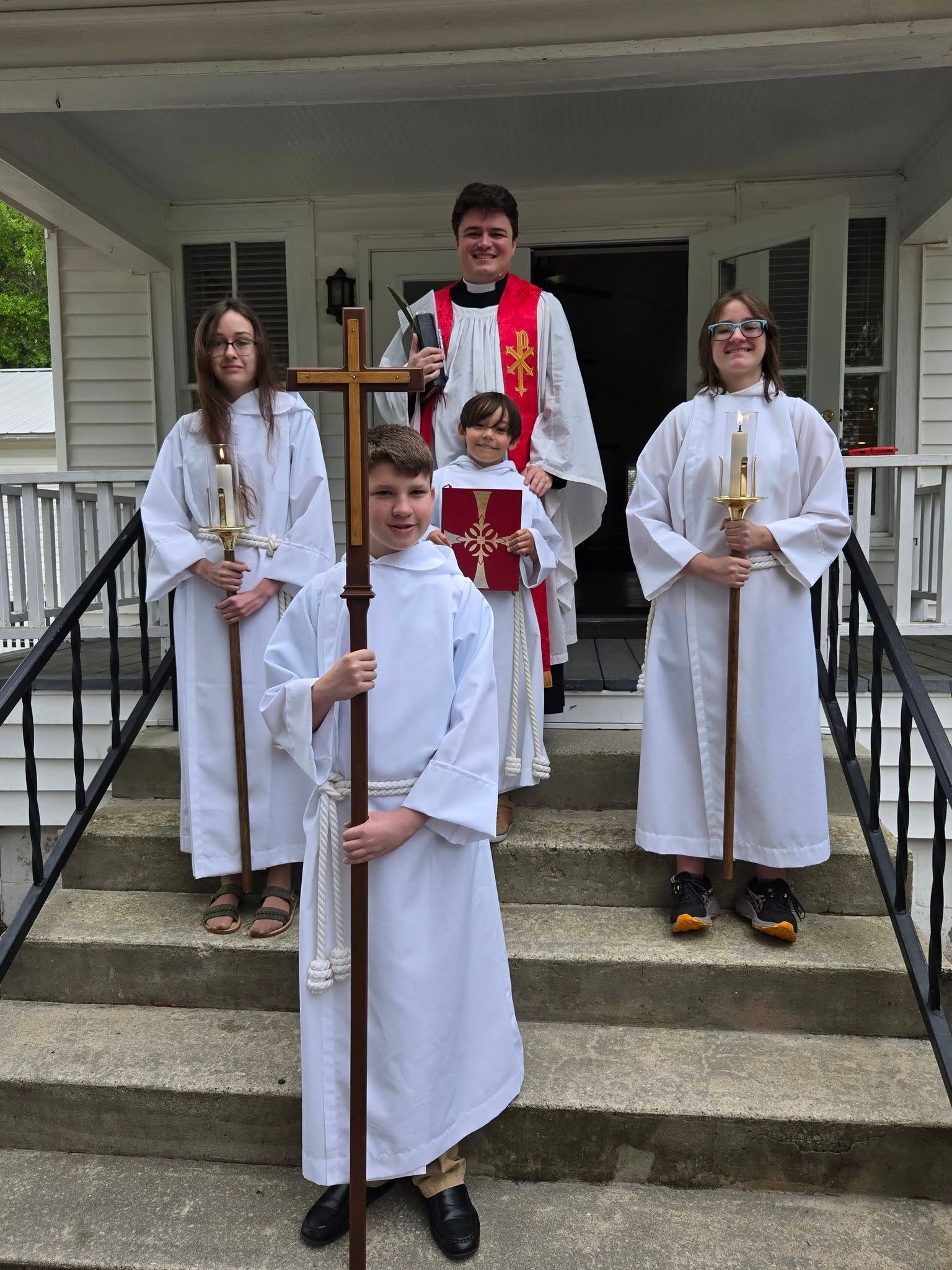 Fr. William and a group of acolytes in front of the St. James Parish Hall