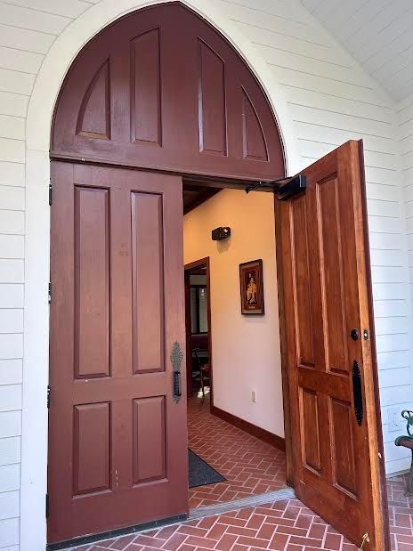 The red front door of the St. James Sanctuary with one side ajar