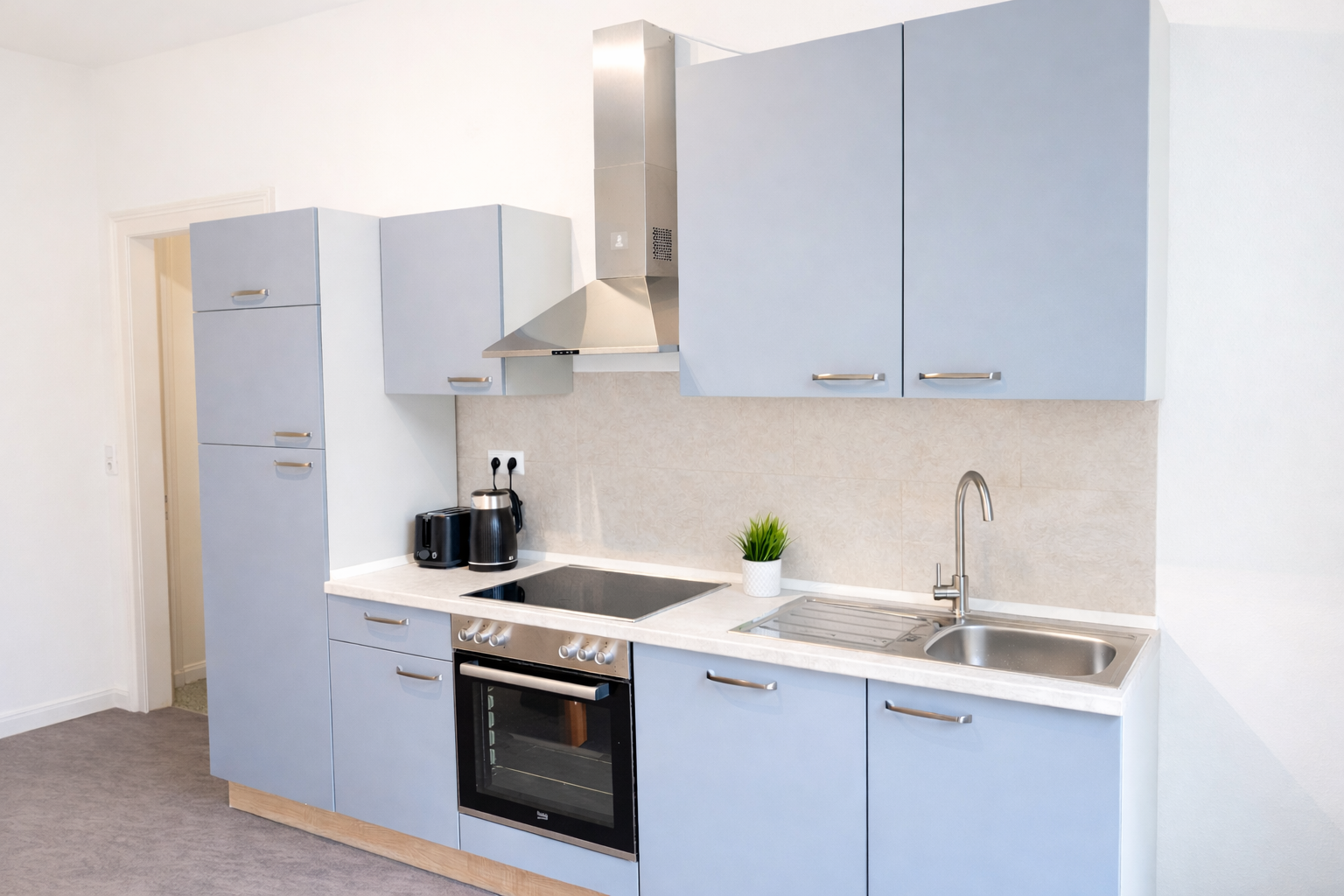 Light blue and white kitchen with stainless steel appliances and a gray countertop