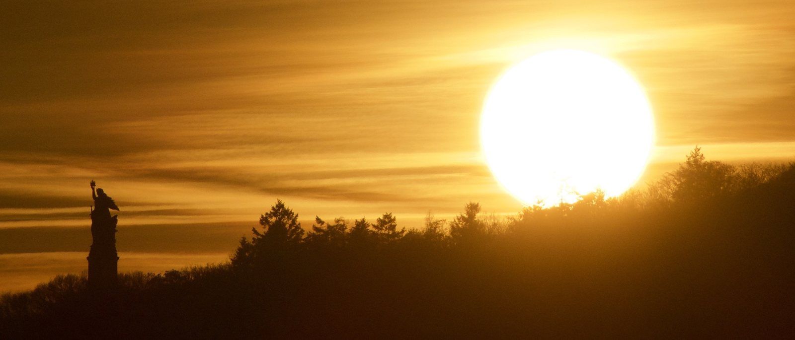 Sonnenuntergang hinter dem Niederwalddenkmal über dem Rheingau