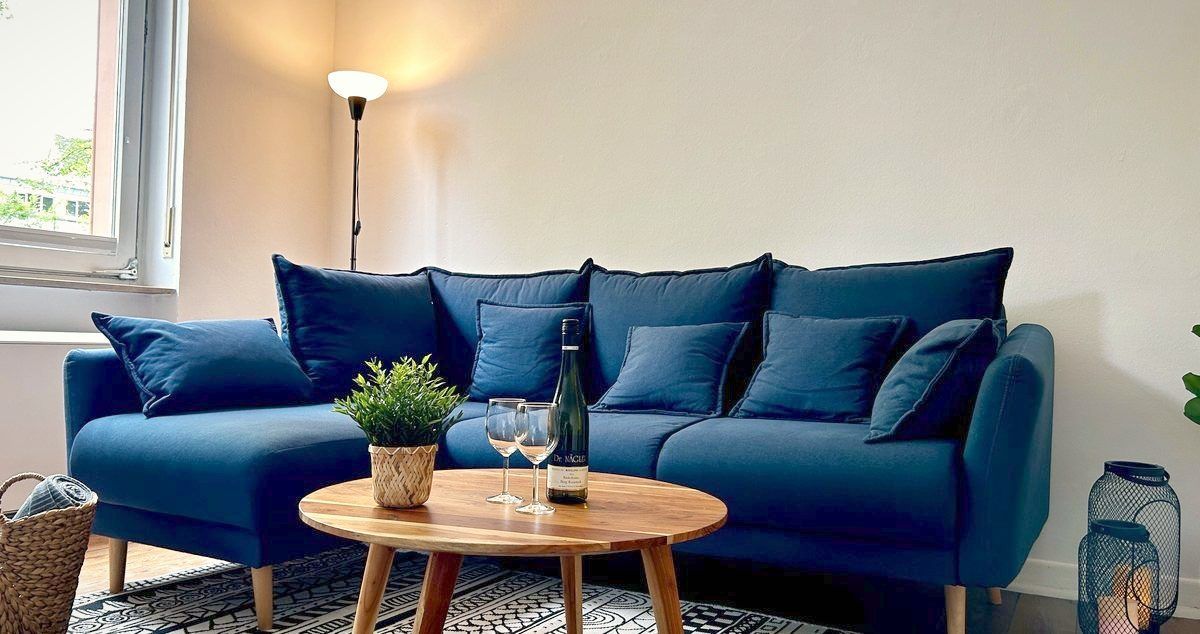 Wohnzimmer des Apartments Riesling im Weingut in Rüdesheim mit Sofa und Rheingauer Riesling