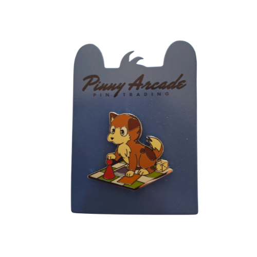 Dog enamel pin on blue card. Brown and white puppy playing on checkerboard.