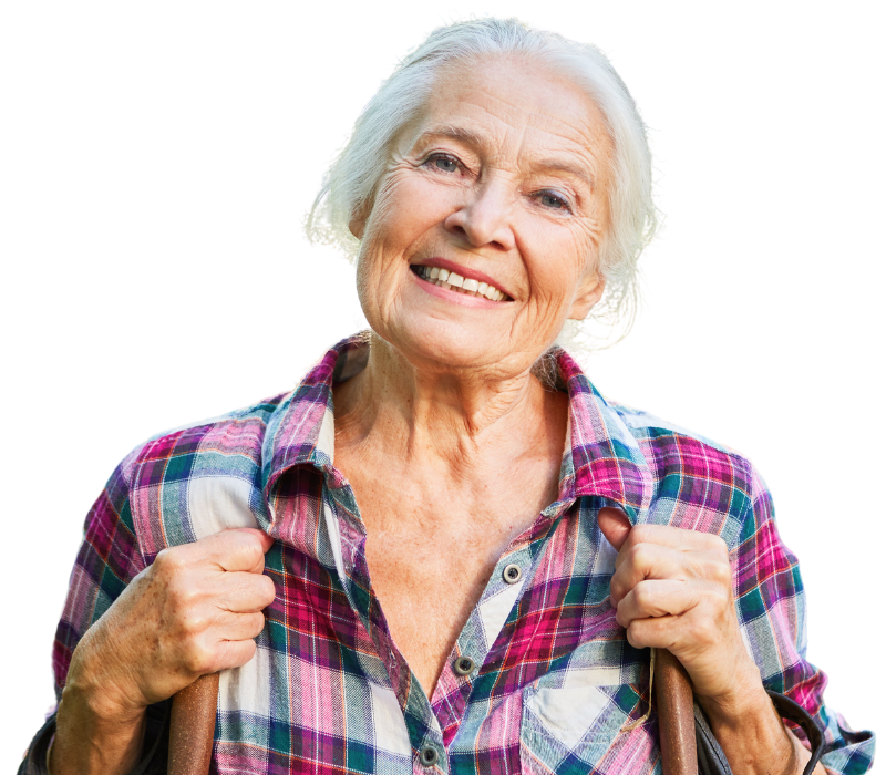 A smiling person with grey hair wearing a plaid button-up shirt, holding the straps of a bag.