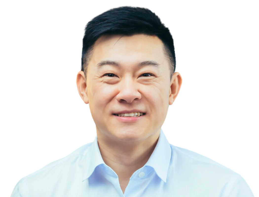 A smiling individual wearing a light blue button-down shirt against a white background.