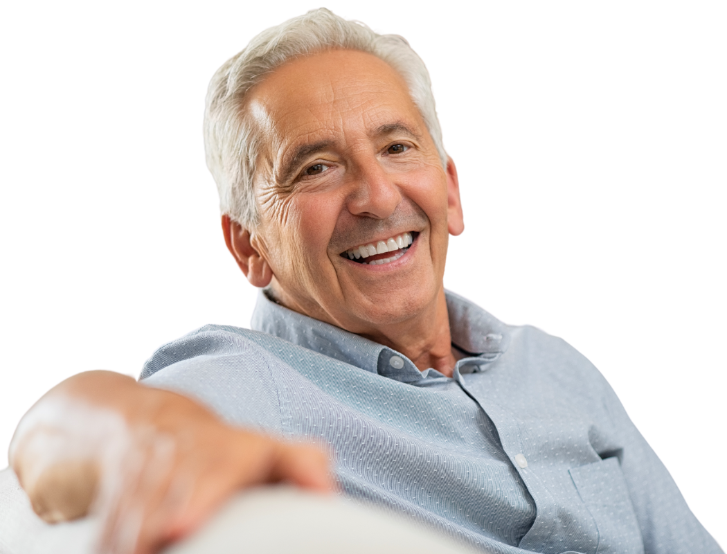 A smiling person wearing a light blue button-down shirt rests their arm on a surface against a white background.