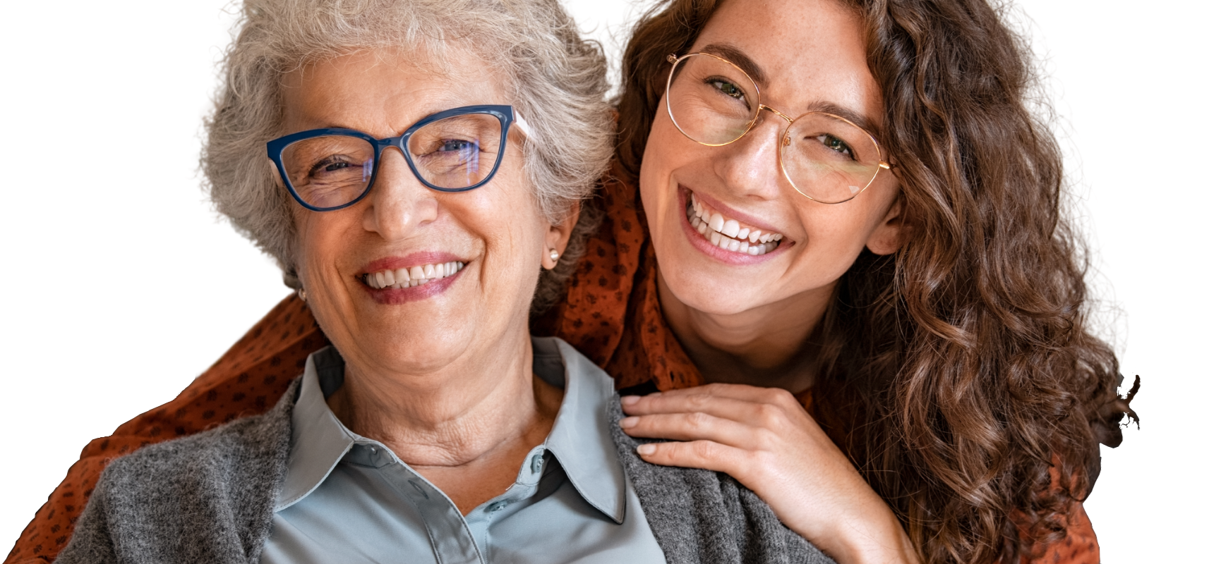 An older person in glasses and a light shirt smiling, with a person behind them resting a hand on their shoulder.