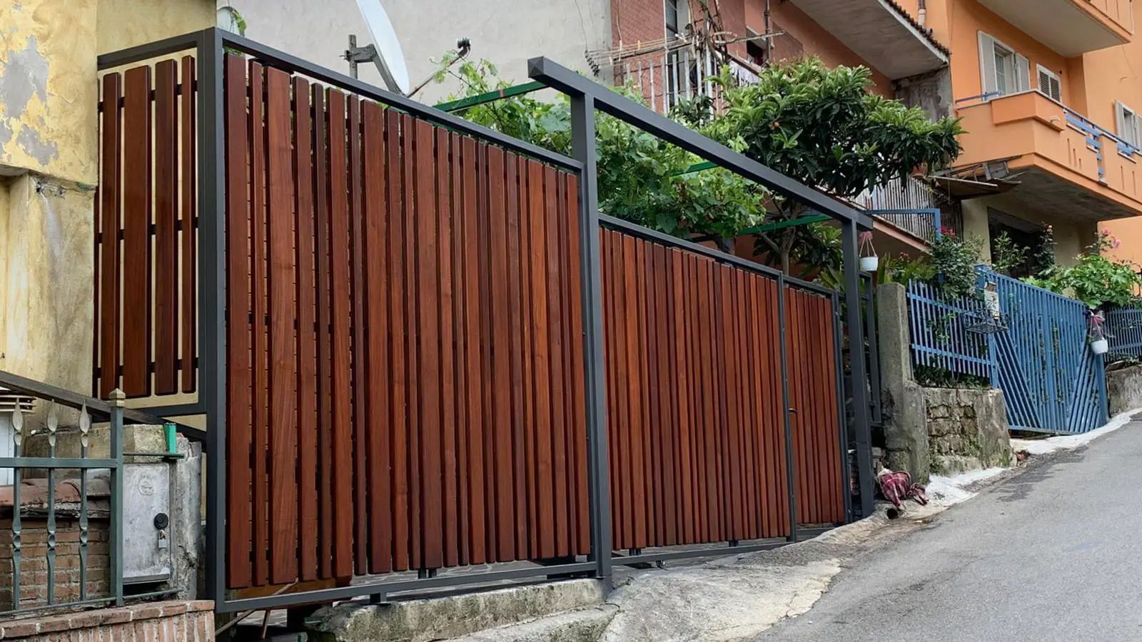 Una staccionata di legno è posta sul ciglio della strada, accanto a un edificio.