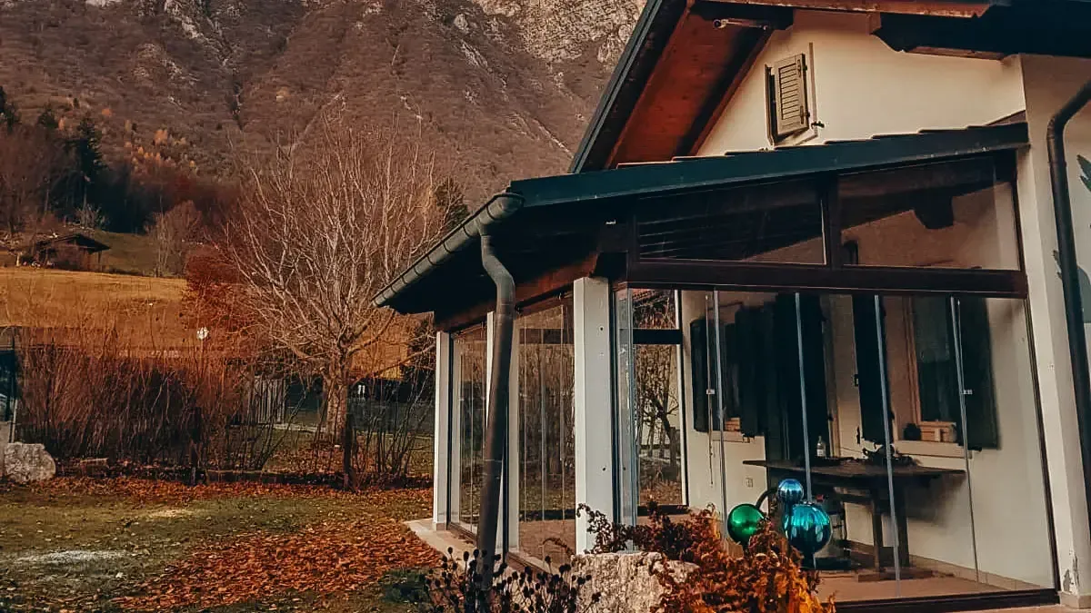 Una casa con un portico e una montagna sullo sfondo.