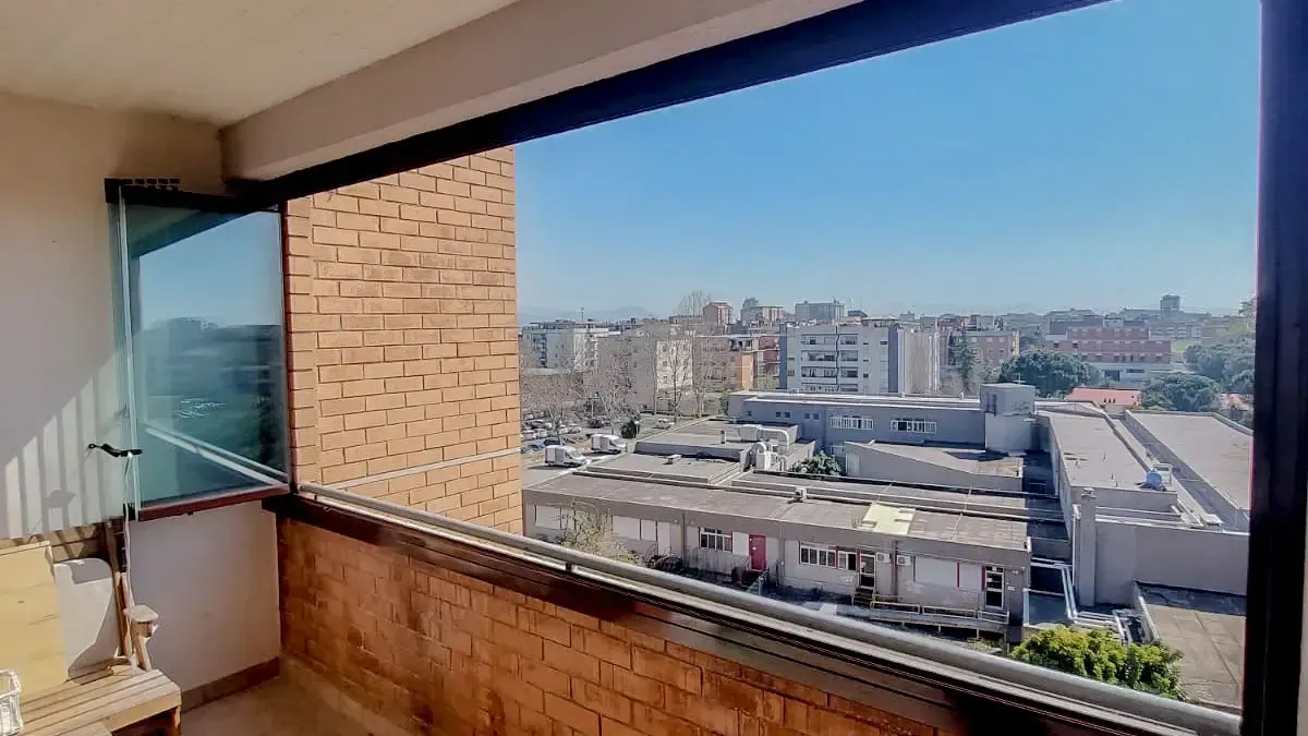 Un balcone con vista sulla città e su un edificio in mattoni.