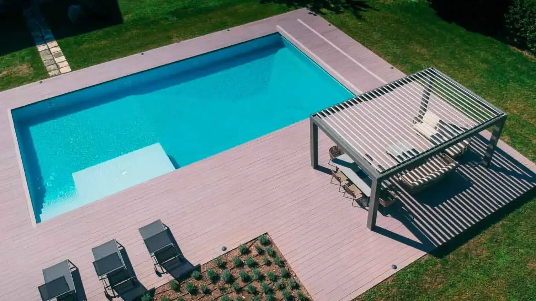 Una vista aerea di una piscina con pergolato e sedie