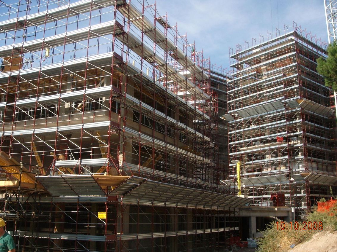In una giornata limpida, un edificio a più piani in costruzione è circondato da impalcature.