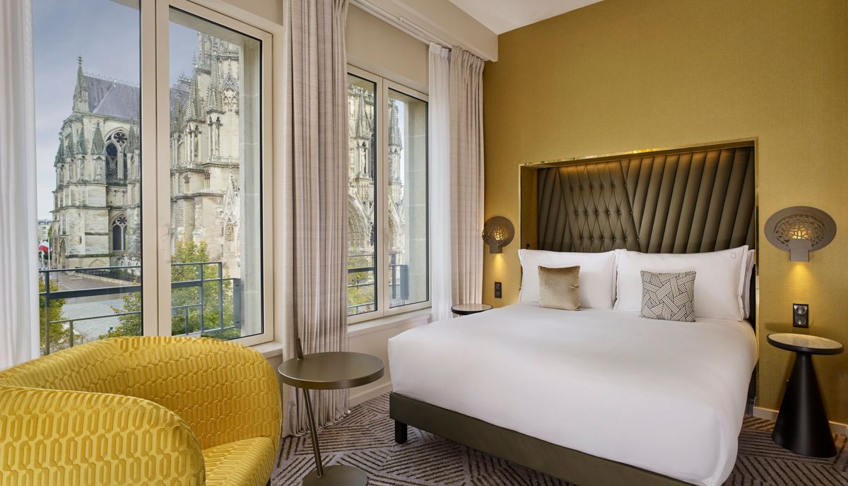 A bedroom with two twin beds and a rug.