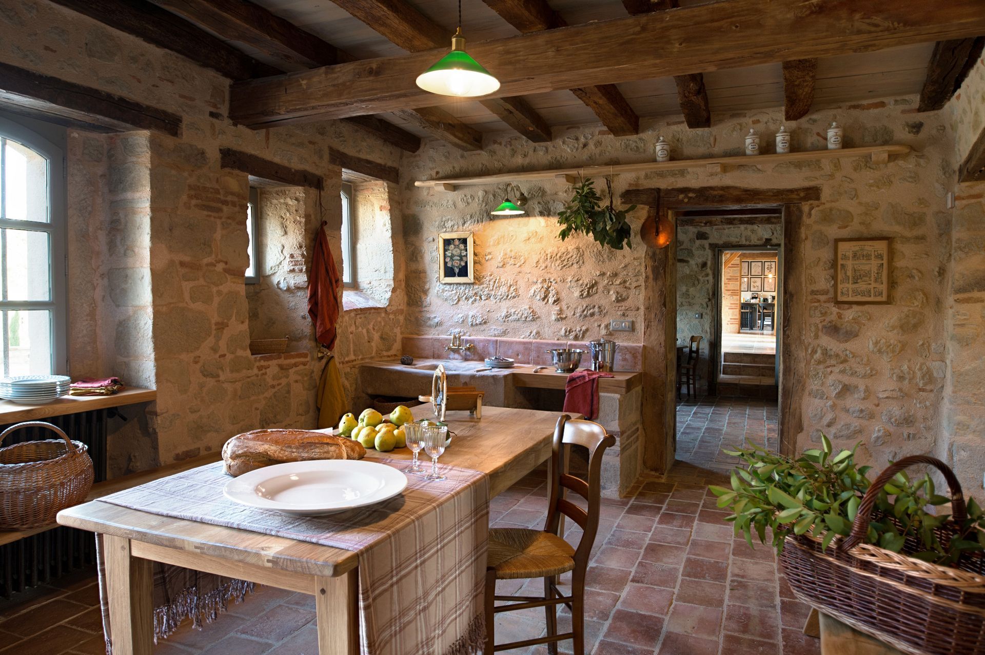 A kitchen with a table and chairs and plates on it.