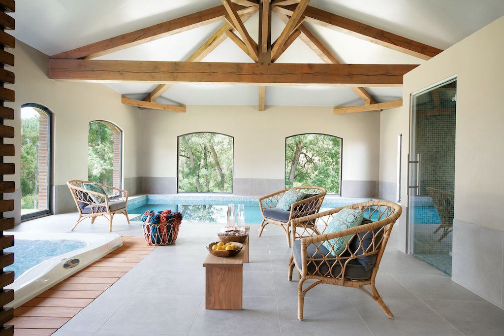 A living room with a swimming pool and chairs