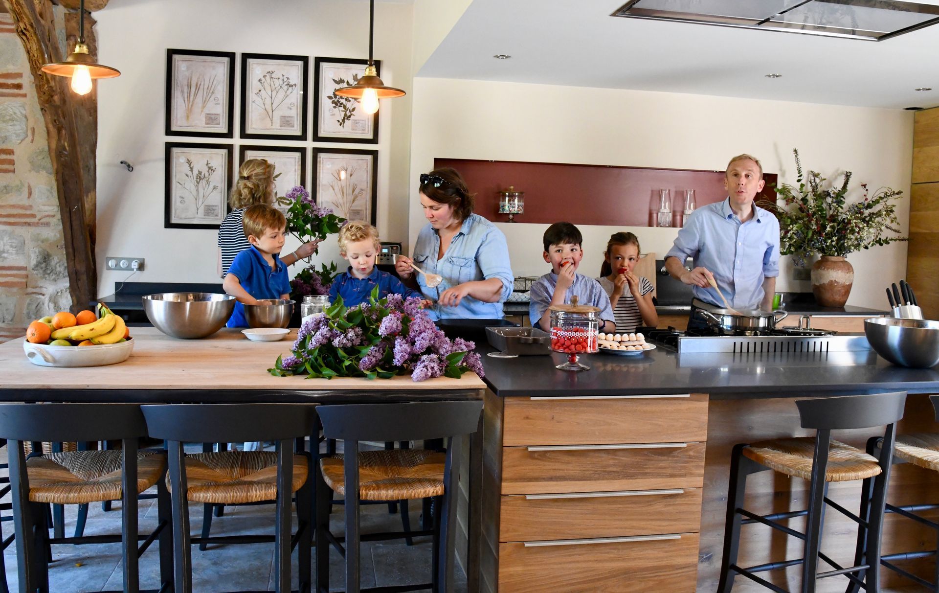 A family is standing in a kitchen preparing food.