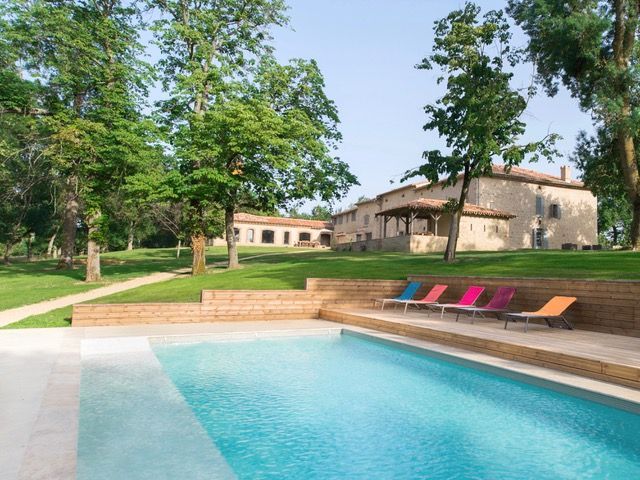 A large swimming pool with a house in the background