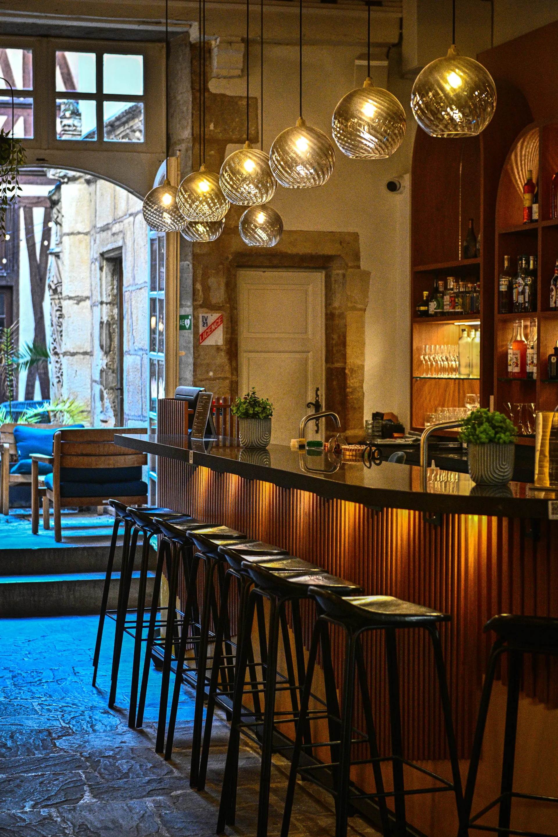 A row of bar stools are lined up in front of a bar in a restaurant.
