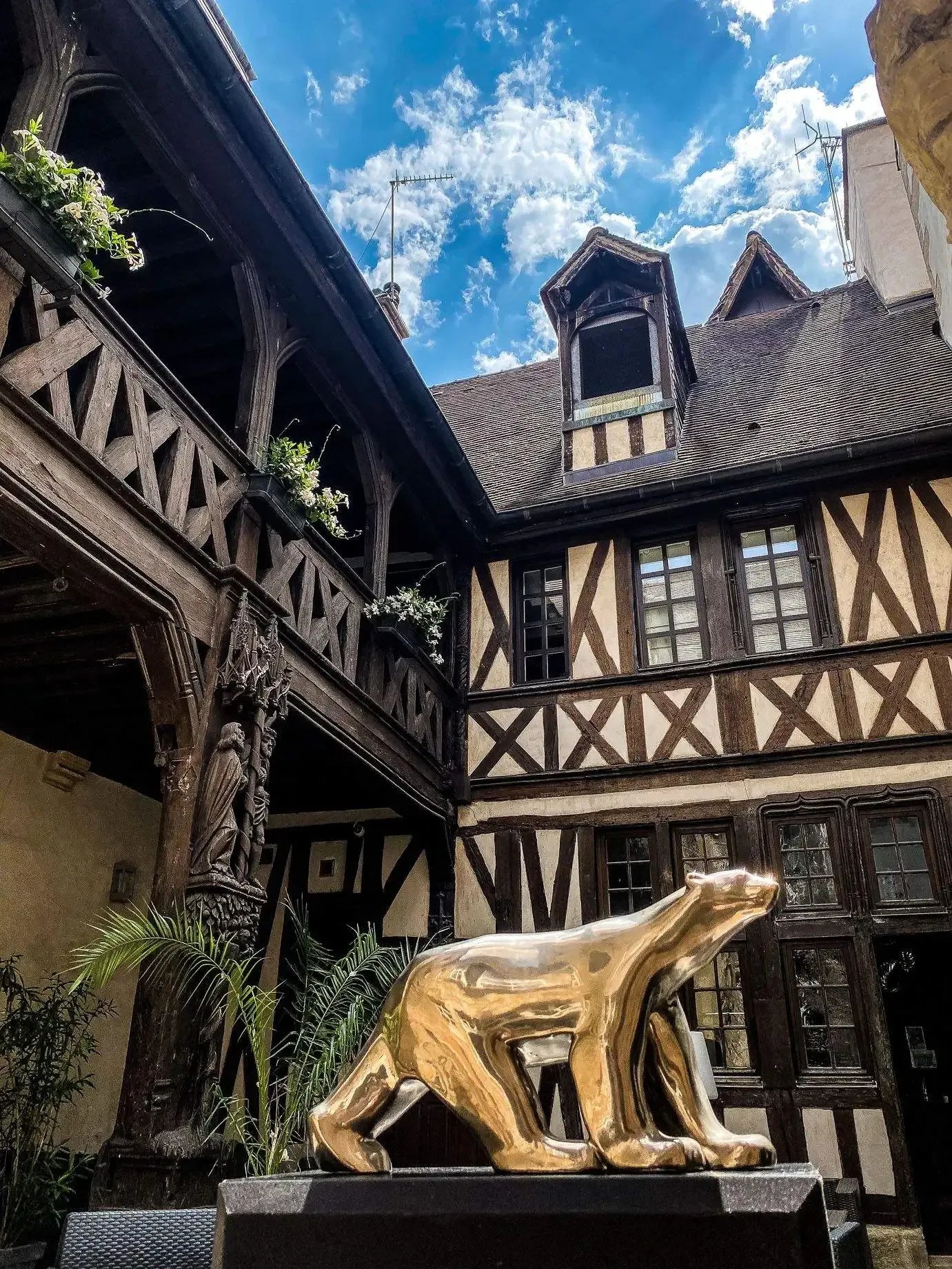 A statue of a bear is in front of a building.
