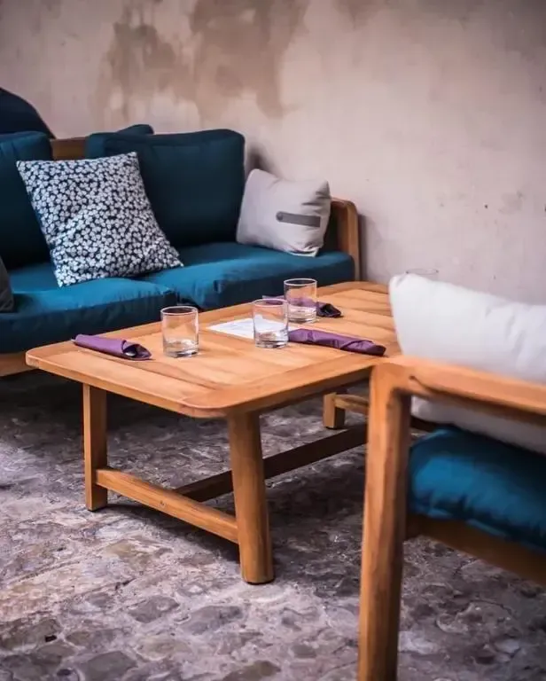 A living room with a blue couch and a wooden table