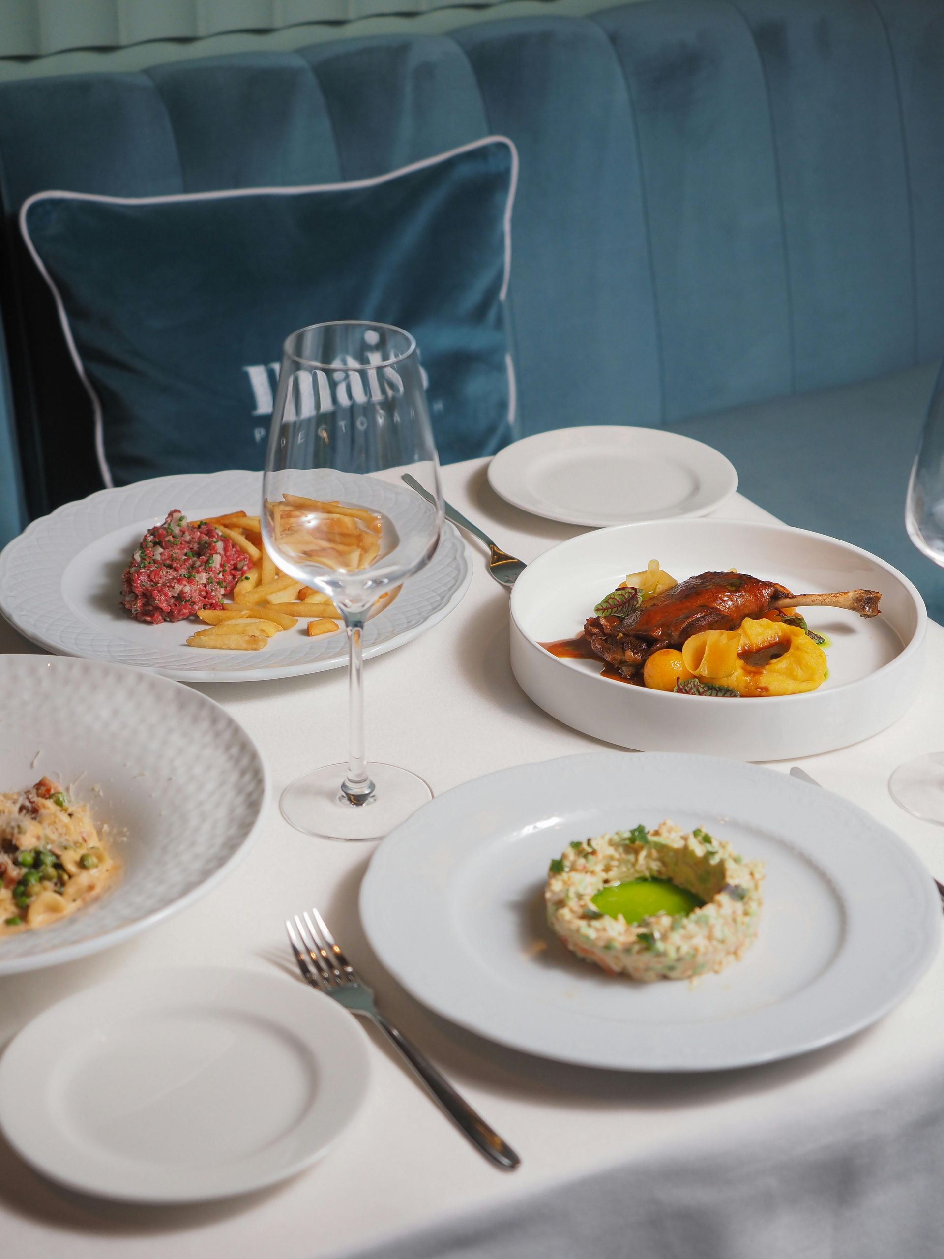 A table with plates of food and a glass of wine