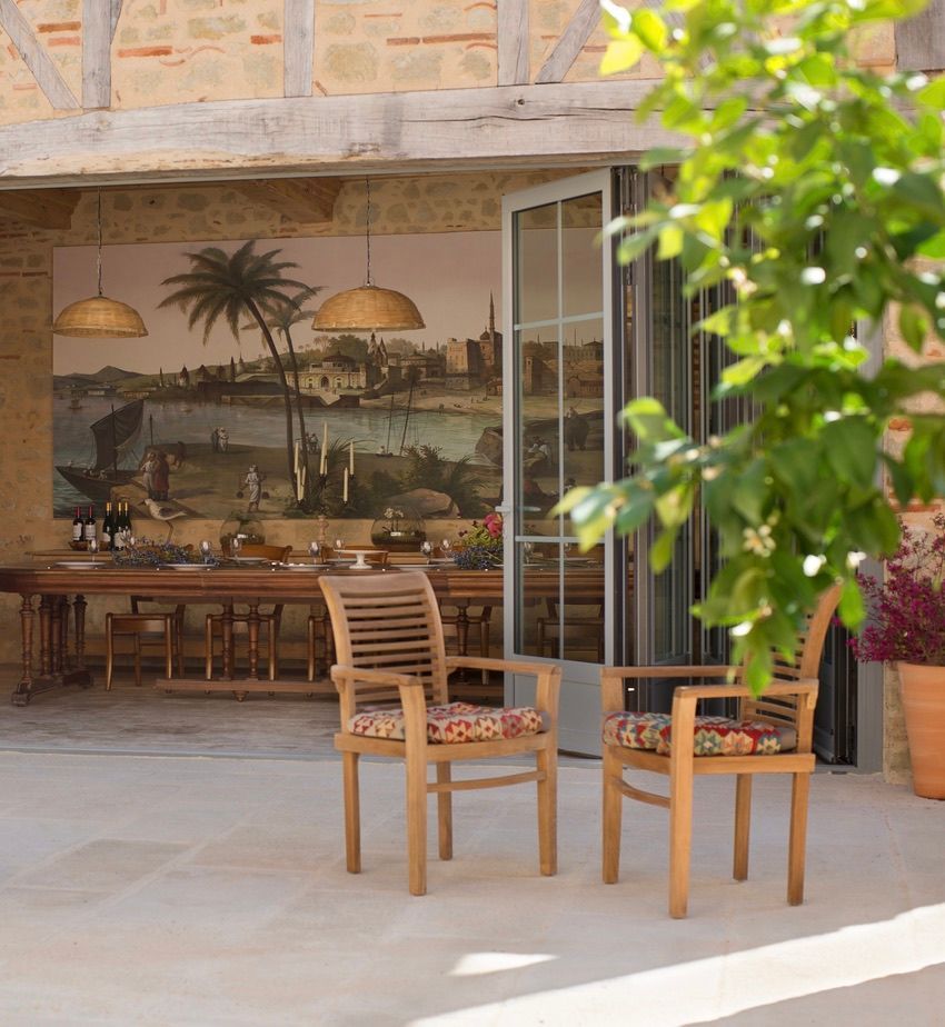 Two chairs in front of a large painting of palm trees