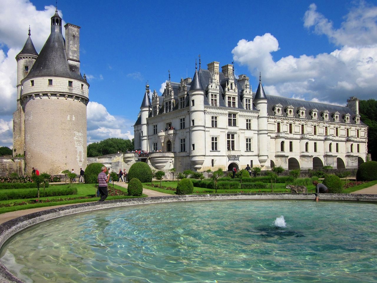 A castle with a fountain in front of it