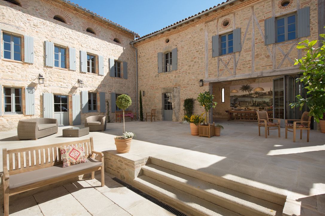 A large stone building with a patio in front of it.