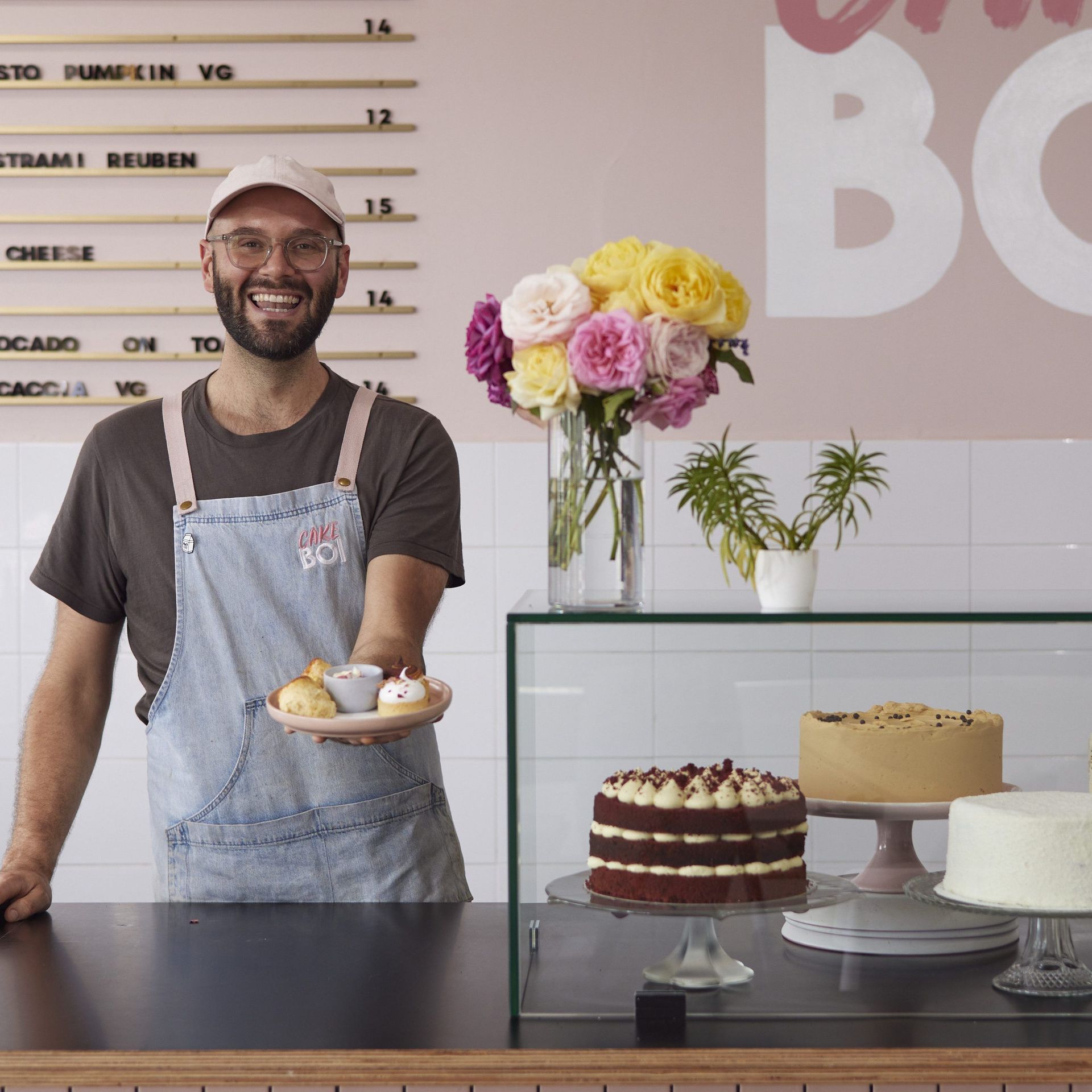A man standing behind a counter holding a plate of food