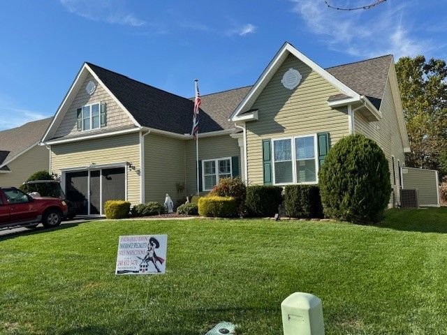 Suburban house with a manicured lawn and a campaign sign near the curb
