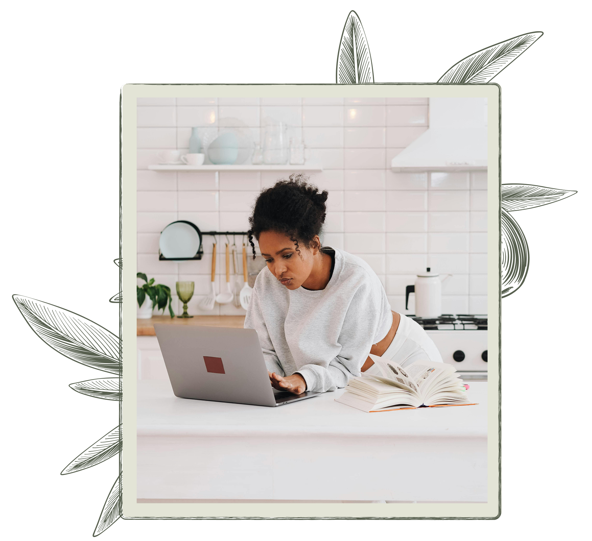 Woman working on a laptop in a bright kitchen.