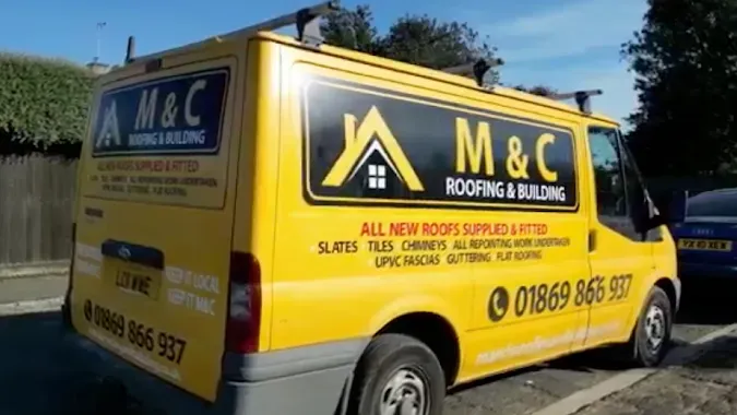 Yellow M&C roofing van parked on a street, with black and white company branding and contact details.