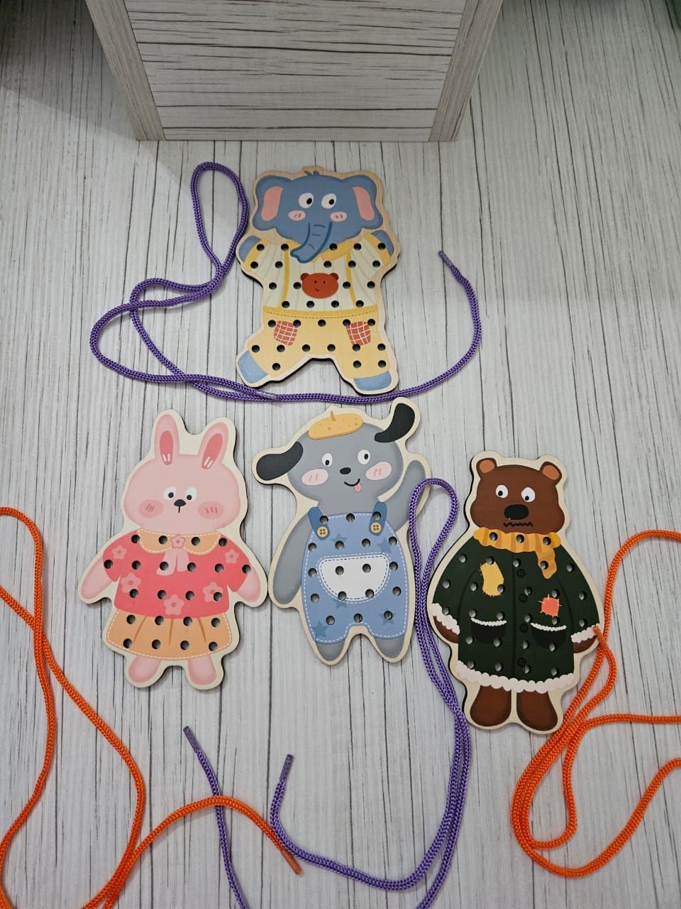 Figuras de animales de madera para coser con hilo de colores.