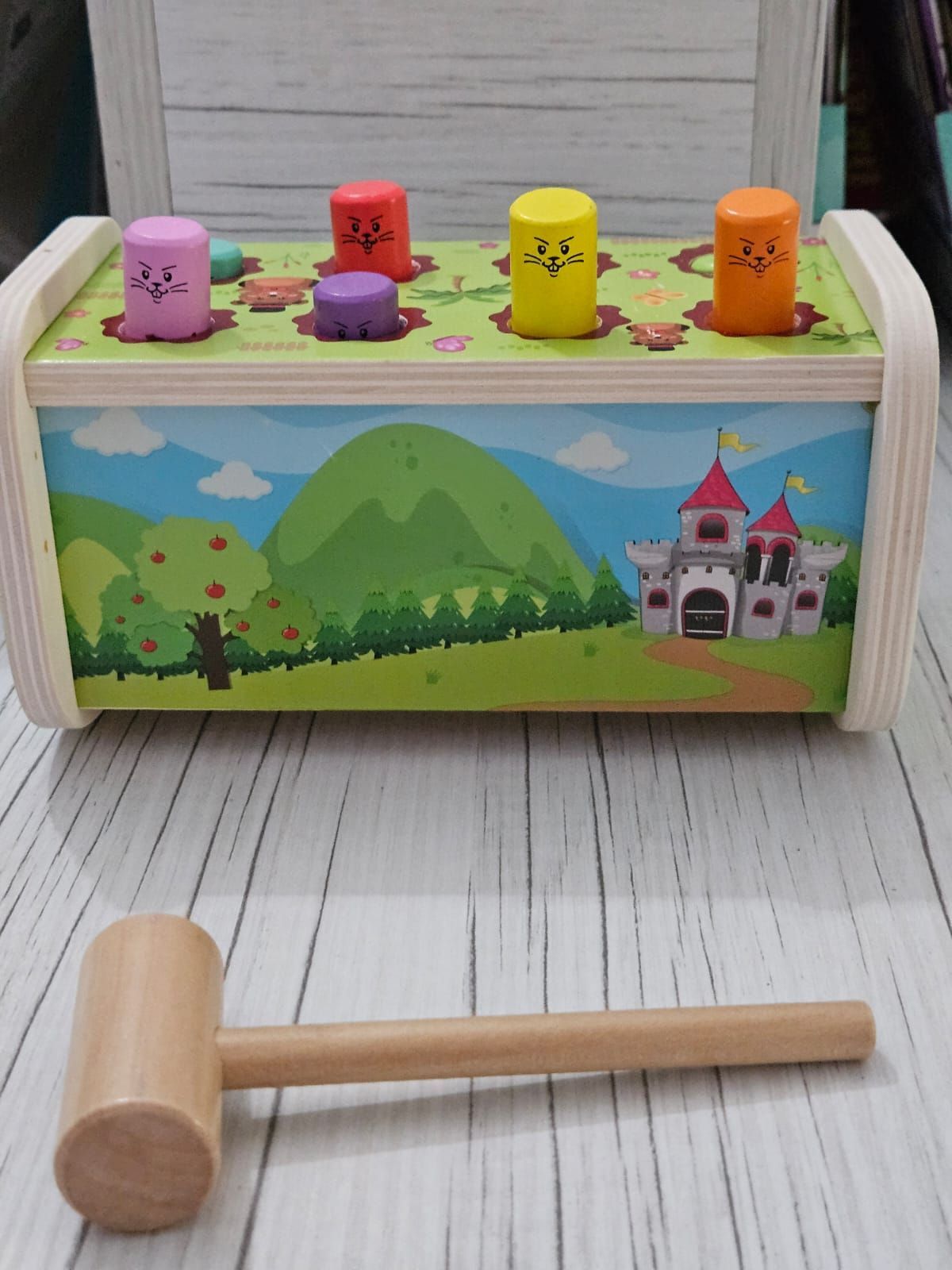 Juguete de madera para golpear con clavijas de colores y martillo, escena de paisaje holandés.