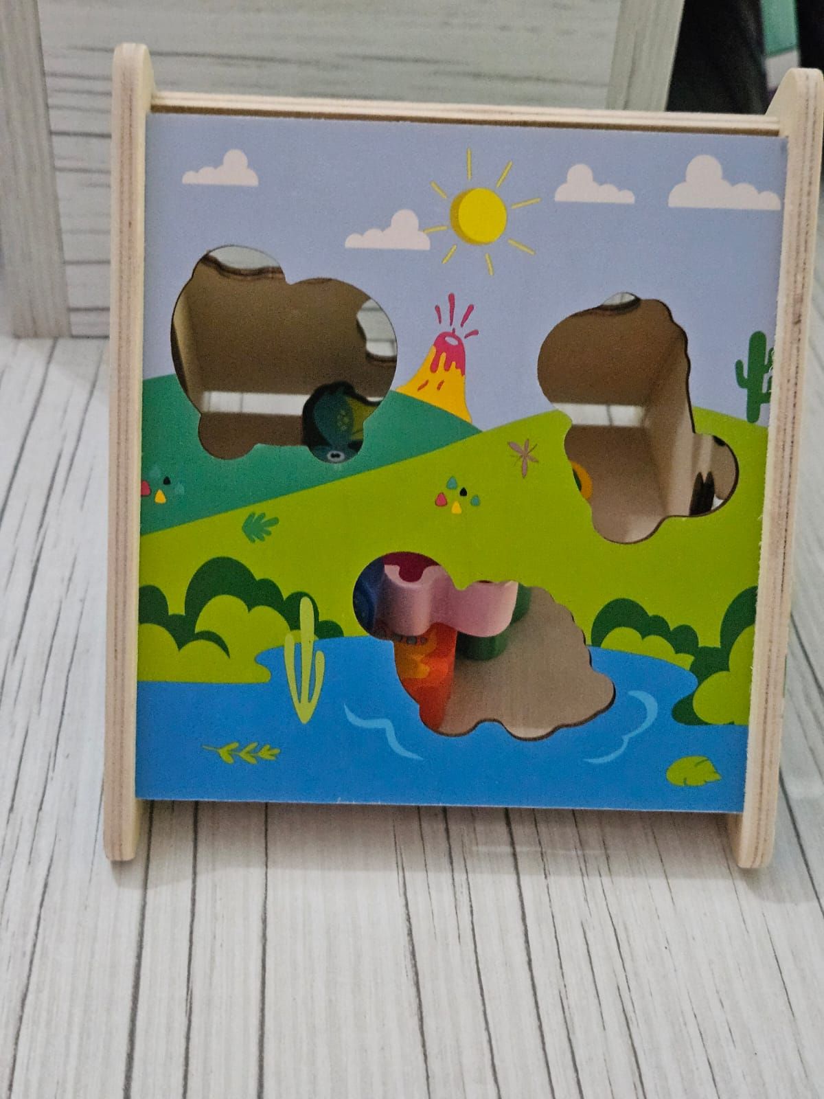 Rompecabezas de dinosaurio de madera con fondo de paisaje pintado.