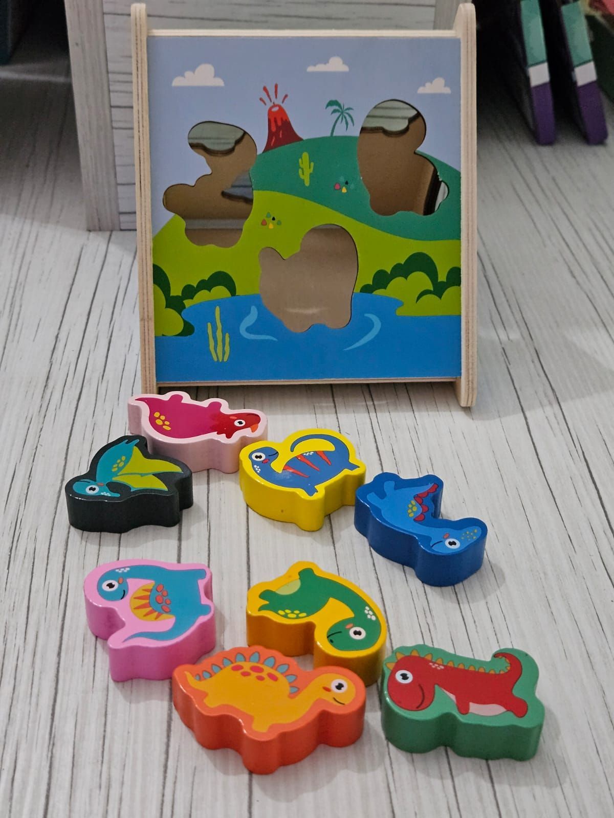 Rompecabezas de dinosaurio de madera con fondo de paisaje pintado.
