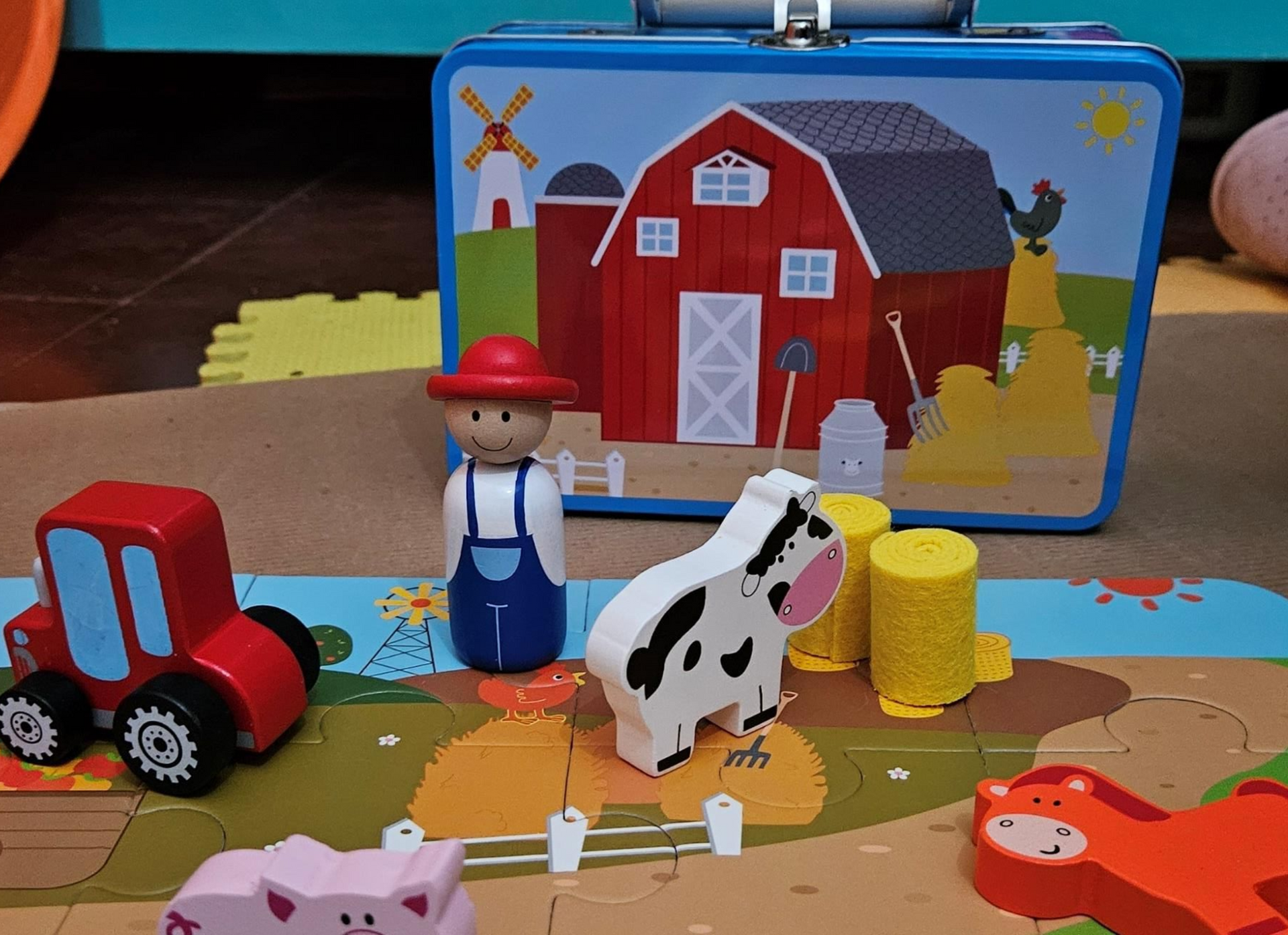 Escena de granja de juguete con granero, tractor, granjero, vaca, cerdo y lonchera.