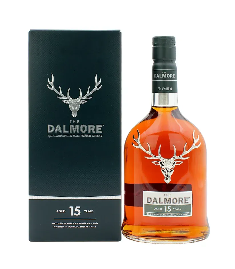 A bottle of The Dalmore 15 Year Old whisky next to its dark blue box.