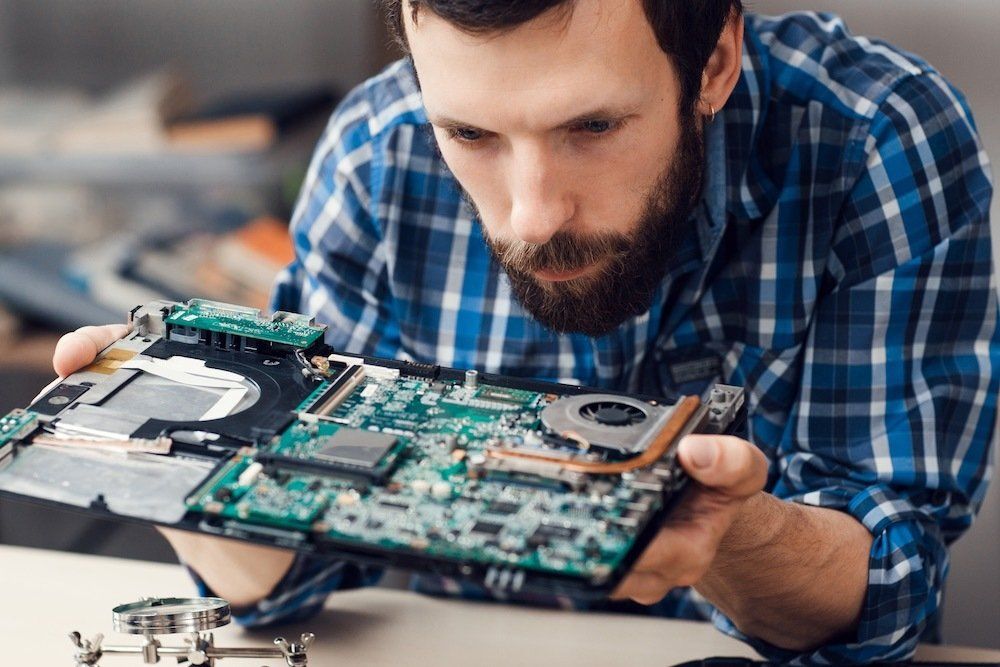 Technician repairing circuit board as part of the upcycling process
