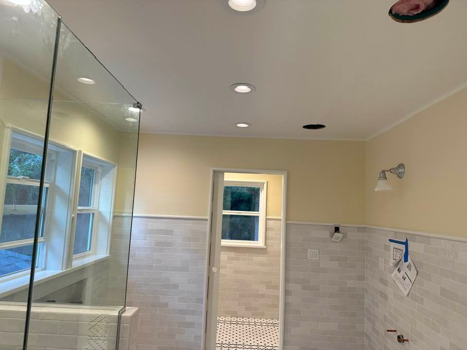 A bathroom with a walk in shower and a window.