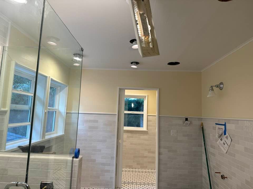 A bathroom with a walk in shower and a window.
