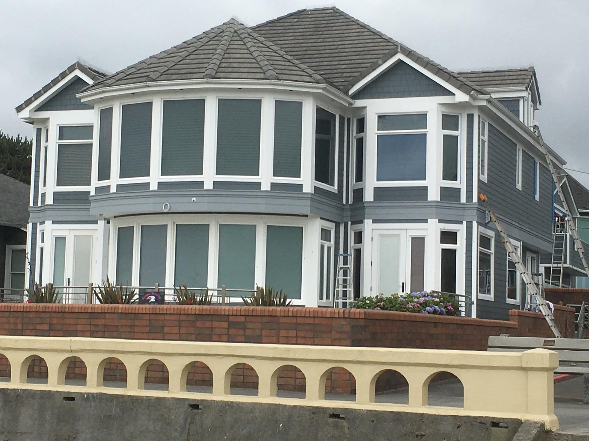 A large house with a lot of windows and a bridge in front of it