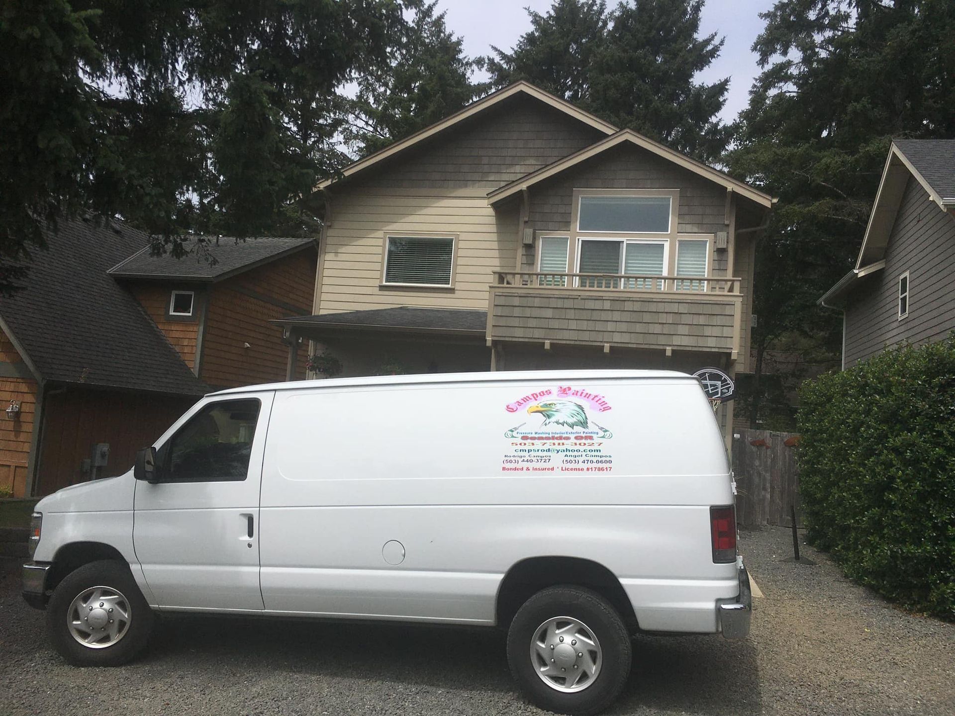 A white van is parked in front of a house