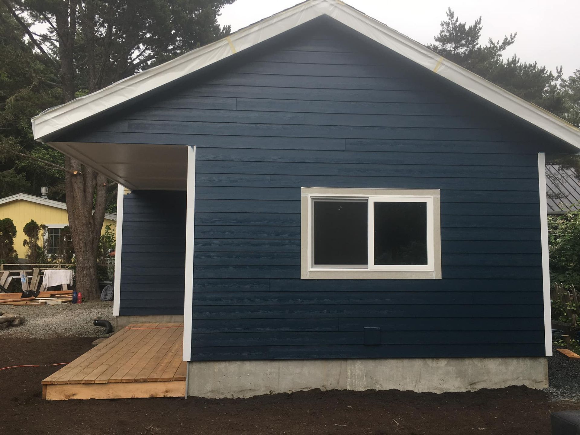 A blue house with a white roof and two windows