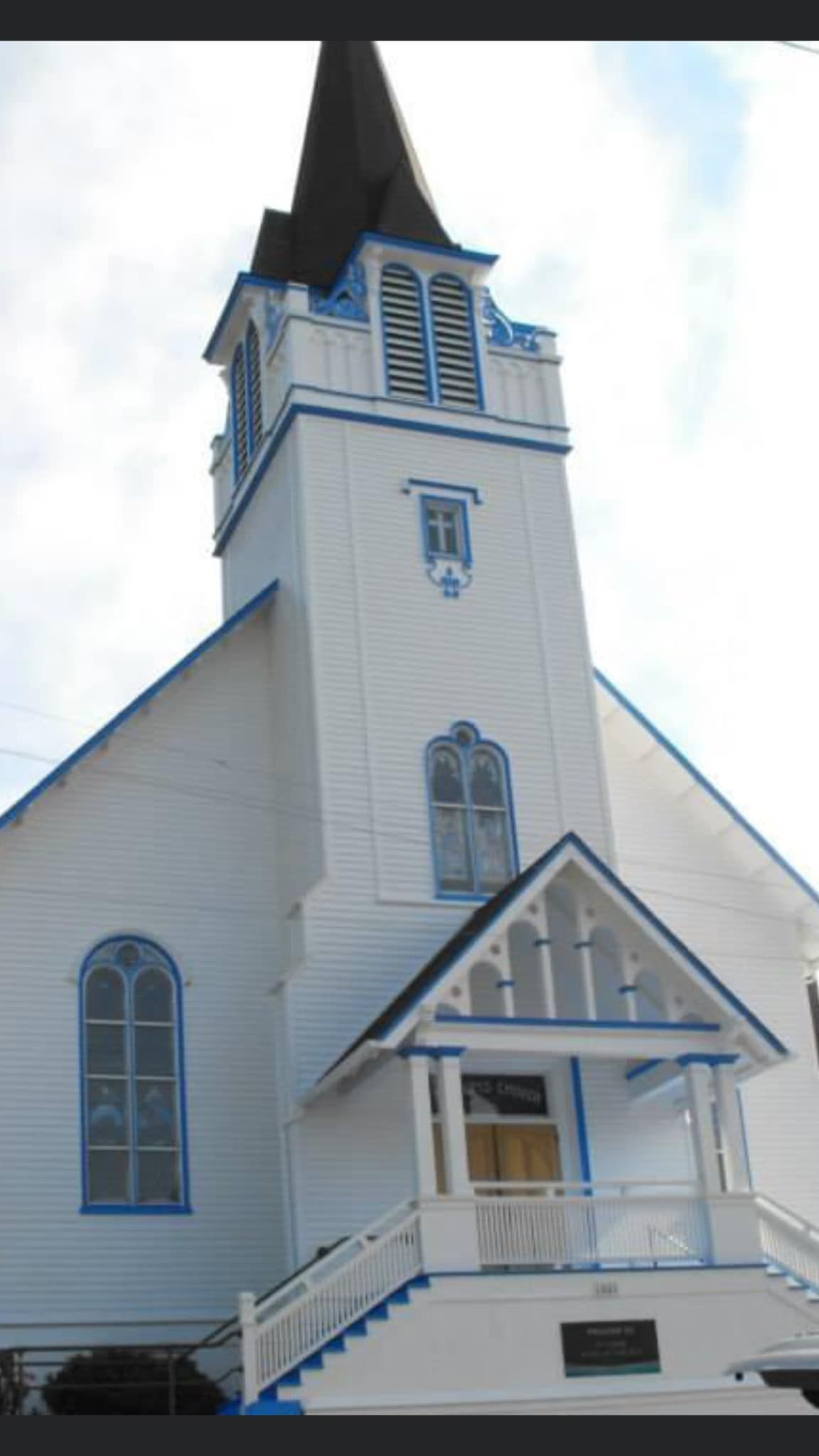 A white church with blue trim and a steeple